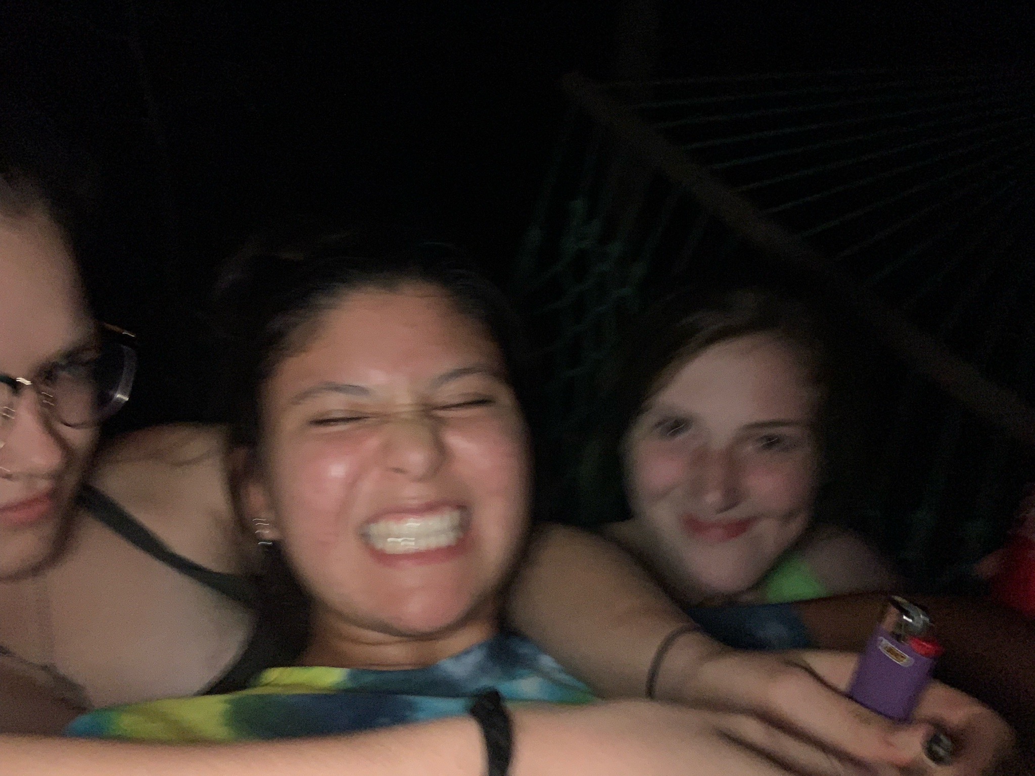 Jade baring her teeth while JQ holds her and Ashley smiles at the camera.